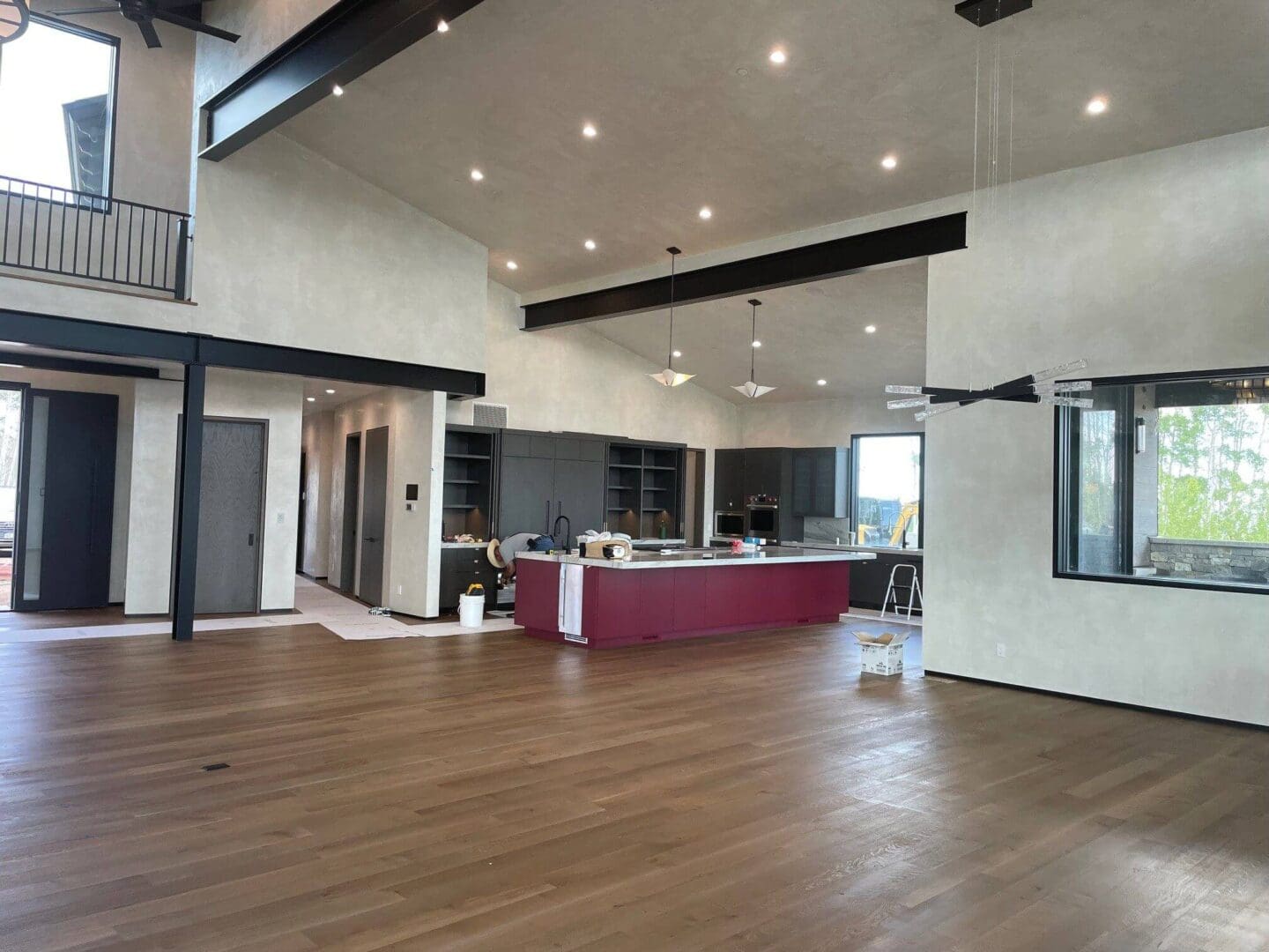 Spacious modern kitchen with sleek design and wooden flooring.