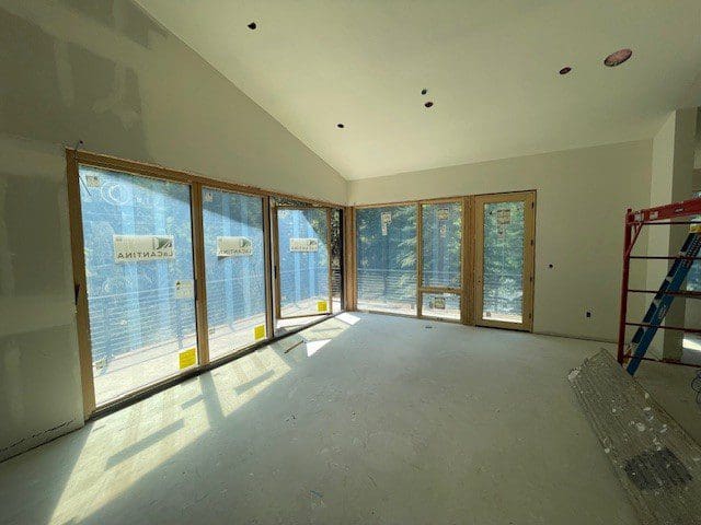 Bright empty room with large windows and concrete floor.