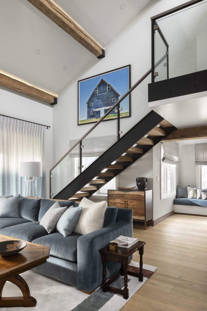 Modern living room with floating staircase and large wall art.
