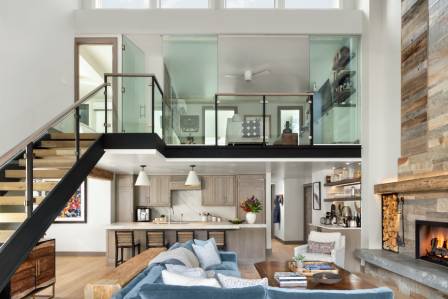 Modern living room with glass mezzanine and cozy seating.