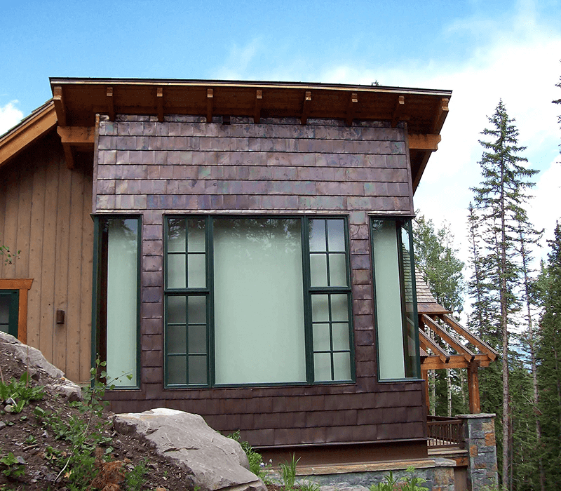 Modern house exterior with large windows and wooden siding.