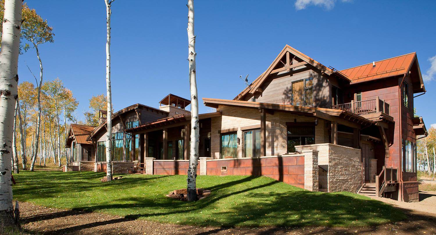 Modern house with large windows and a spacious yard.