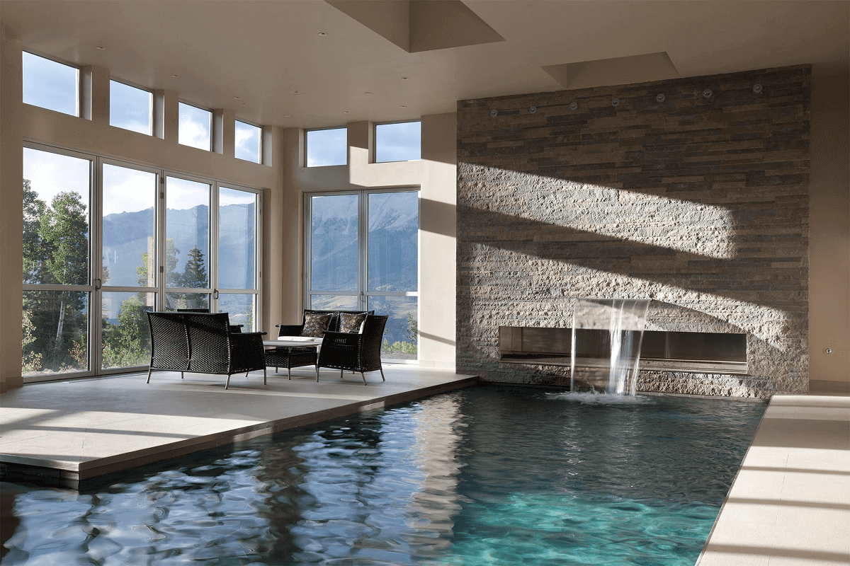 Luxurious indoor pool with large windows and mountain views.