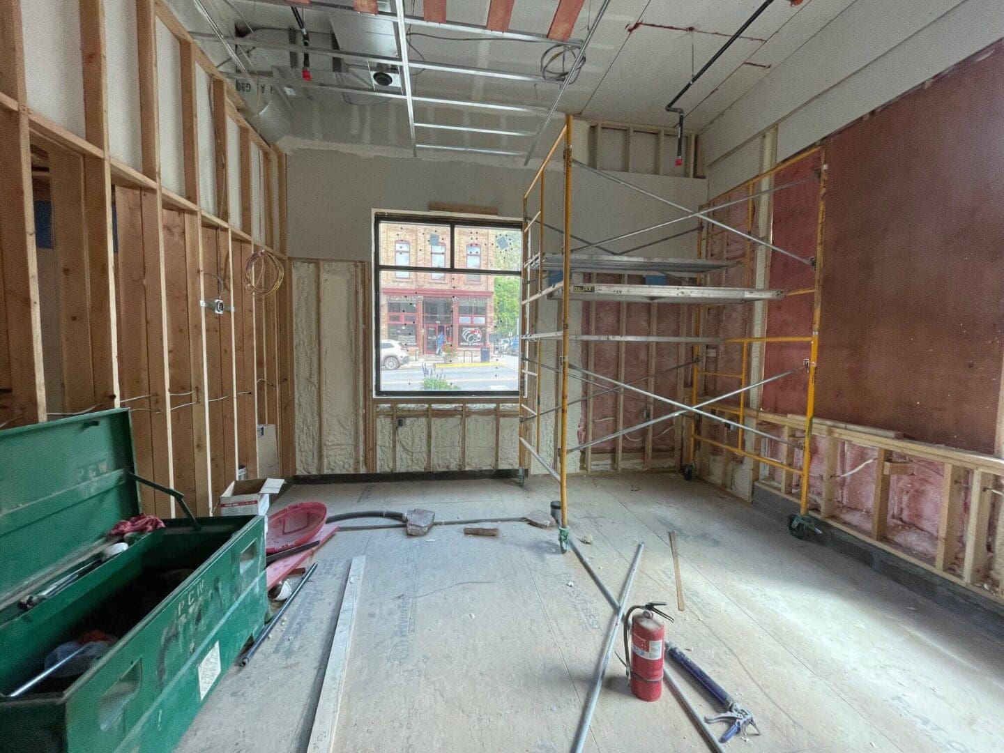 Interior of a house under construction with exposed framing and scaffolding.